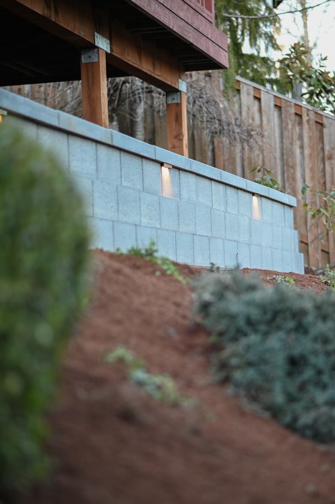 a retaining wall next to bushes